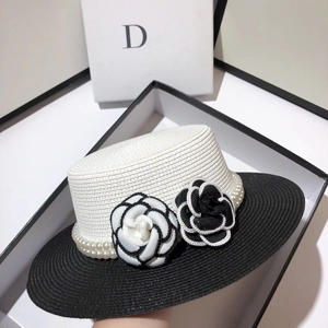 Detailed close-up of straw hat featuring pearl beads and camellia flower accents