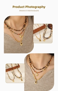Detail of beaded sun pendant necklace and brown gemstone drop layered necklace
