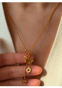 Detailed shot of 24K gold plated necklace with horse, coin, and bead charms