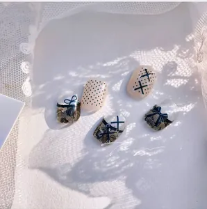 Macro shot of bow and lace nail stickers with polka dots and cross strap designs