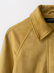Macro detail of mustard yellow suede bomber jacket collar and textured fabric surface