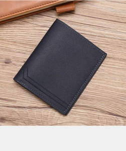 Detail of dark blue lychee grain leather wallet with precision V-shaped stitching