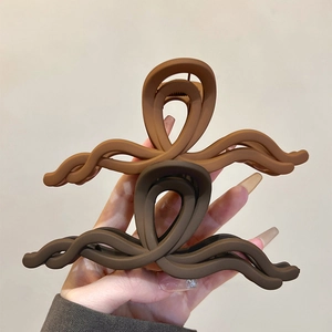 Primo piano di fermagli per capelli opachi e ondulati in marrone e caffè scuro per lo styling