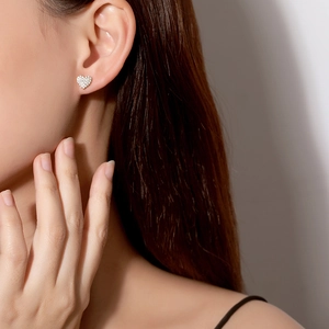 Elegant heart-shaped stud earrings with full pavé crystals on a model for daily wear