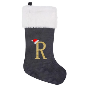 Detail of black velvet Christmas stocking with white plush cuff and gold letter R embroidery
