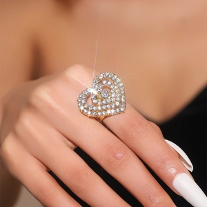 Detailed view of luxury gold multi-layer heart ring paved with sparkling crystals on hand