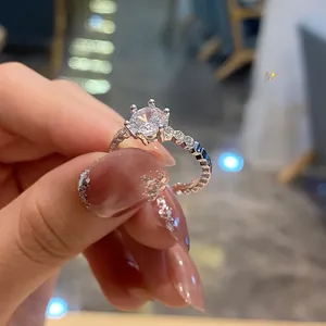 Close-up of a classic six-prong sparkling zircon ring with a micro-pave diamond band