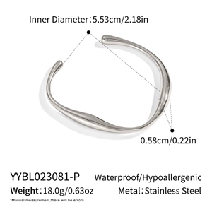 Macro view of silver stainless steel open cuff bracelet with irregular wavy texture