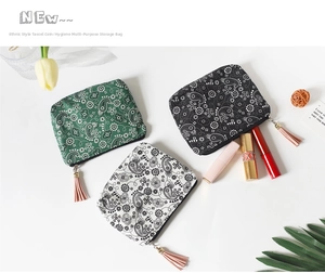 Detailed flat lay of patterned coin purses with tassels and floral mandala motifs