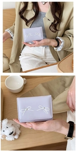 Detail of lavender PU leather wallet with pearl bow and beautiful script decoration