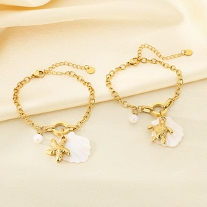 Golden ocean theme bracelet with starfish shell and pearl charms on silk background