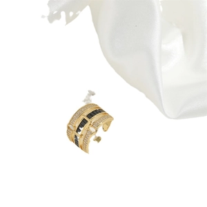 Gold wide band ring featuring a black rectangular zircon and small clear crystals