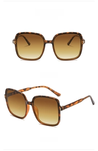 Detail view of square tortoiseshell sunglasses with brown gradient lenses and metal accents