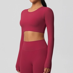 Détail de l'ensemble de yoga bordeaux avec haut court à manches longues et legging taille haute
