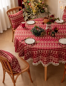 Close-up of red Christmas reindeer tablecloth with gold fringe and matching seat covers
