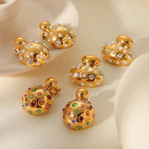 Golden titanium steel earrings with pearls and colorful rhinestones in a luxury scene