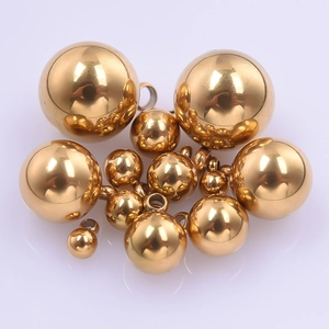 Détail de pendentifs boules en acier inoxydable doré de tailles variées avec anneau