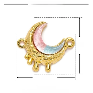Detailed macro view of a 20mm gold crescent moon pendant with pink blue enamel inlay