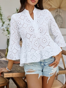 Détail de la broderie en dentelle blanche sur chemisier à col en V avec manches évasées