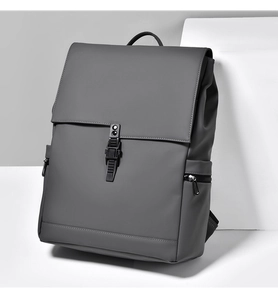 Detail of dark grey business backpack with matte texture, buckle flap, and side pocket