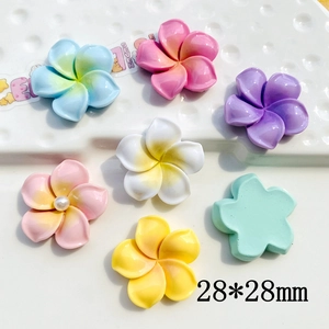 Flat lay of colorful 28mm resin frangipani flower charms for DIY accessories and crafts