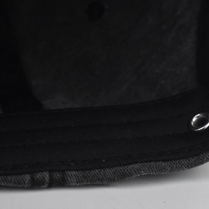 Close-up of deep gray washed cotton baseball cap showing metallic eyelet and reinforced stitching