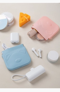 Detailed view of pink and blue silicone cartoon pouches for earphones and coins