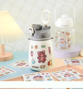 Close-up of a white insulated mug featuring cute cartoon bear and rabbit DIY stickers