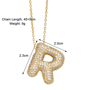 Detail view of the letter R gold necklace with zircon stones and dimension markings