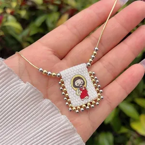 Close-up of handmade religious pendant with cartoon Jesus and gold snake chain