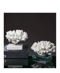 Dettaglio della statua di corallo bianco su base di marmo con eleganti finiture in oro