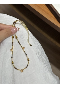 Close-up of handmade beaded necklace with gold tubes, tiger eye stones and adjustable chain