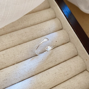 Adjustable S925 silver ring featuring hands hugging a small opal in a jewelry box