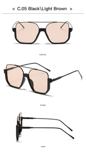 Detail view of double-bridge sunglasses in black frame with light brown lenses
