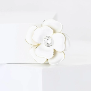 Detail of white enamel flower brooch with gold edging and center crystal for suits