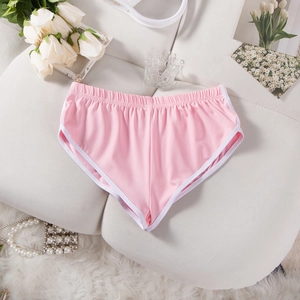 Detailansicht der rosa Sportshorts mit weißer Paspelierung auf dekorativem weißem Hintergrund