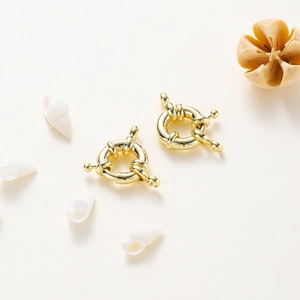 Close-up of 14K gold-plated sailor clasps with seashells and dried flower decor