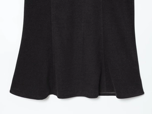 Close-up of black dress hemline showing premium knit fabric texture and fine stitching