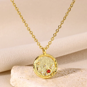 Detail of 18K gold hammered constellation pendant necklace with red and white zircons
