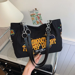Minimalist black canvas tote bag with colorful embroidery and black PU straps