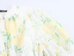 Detailed view of white floral dress with delicate eyelet embroidery and size S neck label