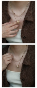 Close-up of double-layer gold necklace with white pearls and zircon cylinder pendant