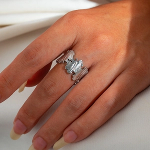 Detailed close-up of a silver titanium steel open ring with a leaf design on finger