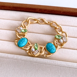Detailansicht eines goldfarbenen Gliederkettenarmbands mit Türkissteinen und Perlen