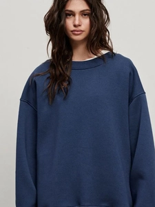 Close-up of deep blue crewneck sweatshirt showing soft cotton knit fabric and loose fit