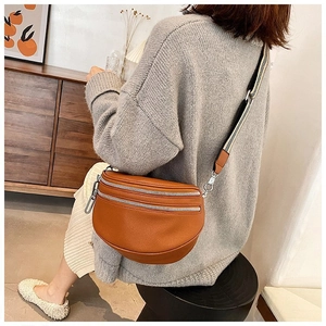 Brown lychee texture waist bag with striped wide shoulder strap worn by a model