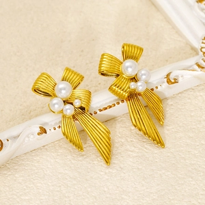 Elegant gold bow earrings with pearls and striped metal texture for a vintage women's style