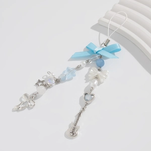Detail of blue bow phone charm with silver guitar, star pendants and pearly beads