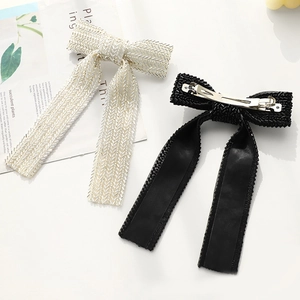 Detail of handcrafted beaded bow hair clips in black and white with metal spring fastener