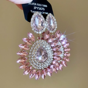 Macro detail of sparkly pink crystal drop earrings with 925 silver studs in flower design